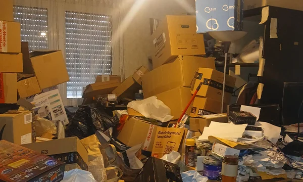 Extremely cluttered property before clearance — contents piled high, barely accessible